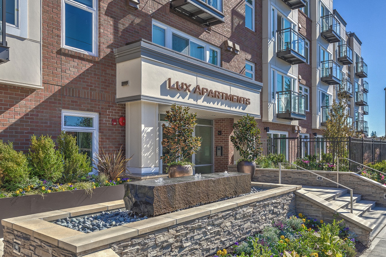Lux Apartments Bellevue WA entryway with fountain and landscaped garden beds